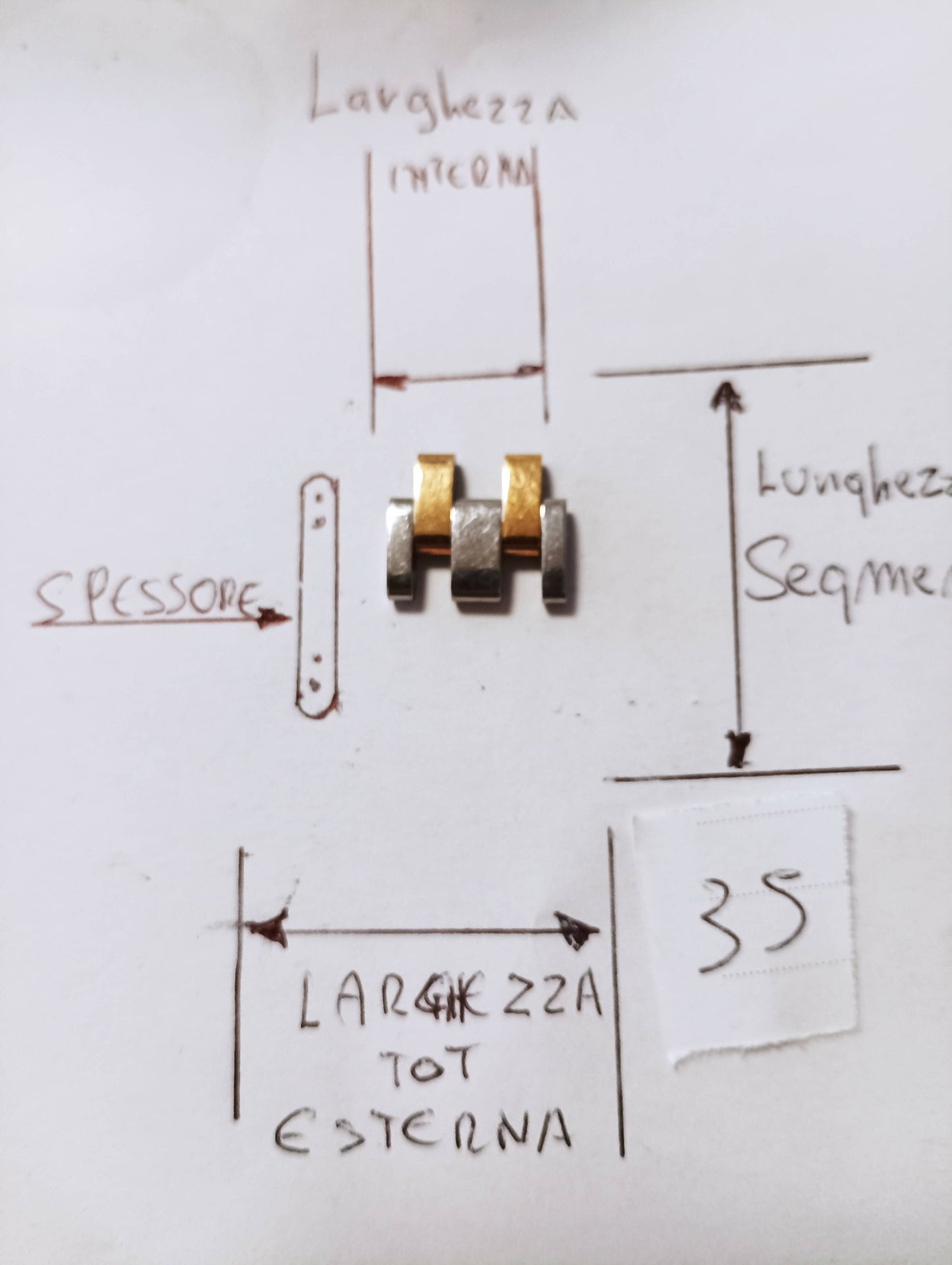 Maglia aggiuntiva per bracciale color acciaio e oro delle dimensioni di massima 15,25 m.m. minima 10,7 m.m. spessore 2,73 lunghezza segmento 9 m.mm