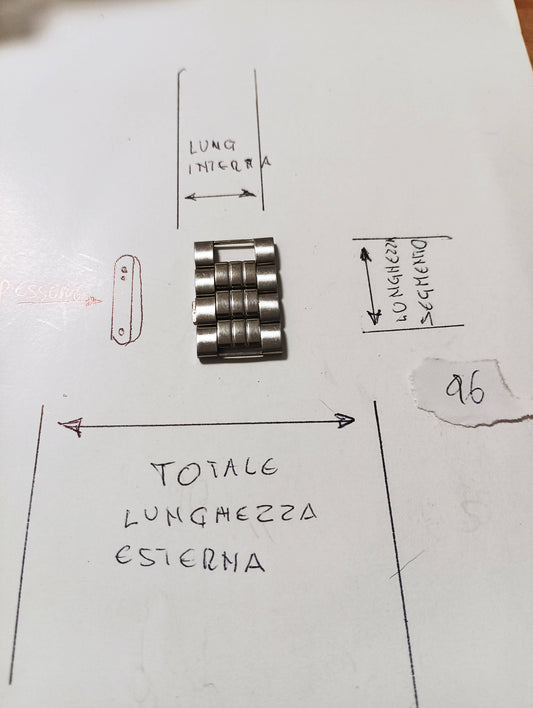 Maglia aggiuntiva per bracciale color acciaio dalle dimensioni di 16,06 m.m. di larghezza esterna e di larghezza minima 8,16m.m. spessore 2,43 m.m. larghezza Segmento 6,27 m.m.